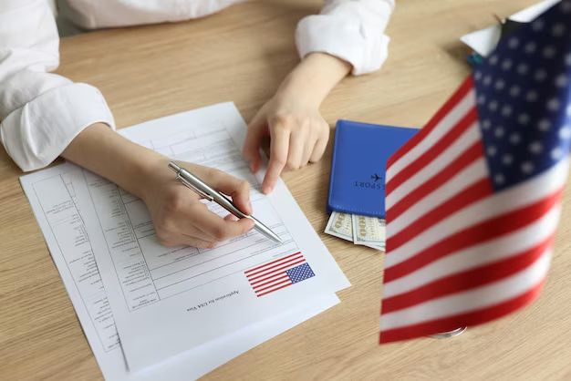 A girl fills out documents, next to an American flag and a passport with money