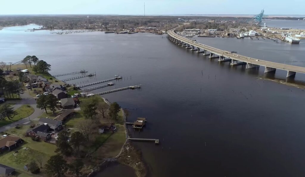 the river and the bridge on the water, the land with buildings and trees on it